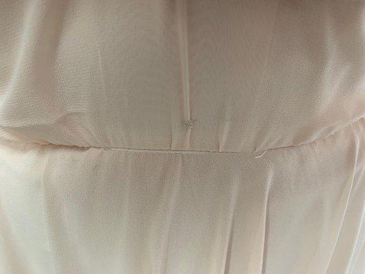 Thread doesn't match and there is a HOLE above where she fixed and tried to fix with unmatching thread