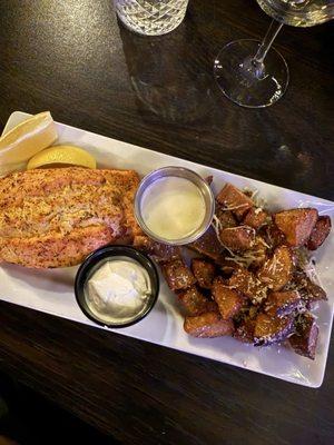 Seafood stuffed salmon with a side of beurre blanc, and parmesean potato bites