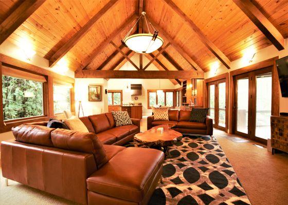 Great Room at Rivers Edge Retreat. Living Room in foreground, dining room and kitchen in the background with windows overlooking the river.