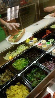 Making our veggie delight footlong on whole wheat