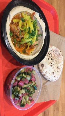 Hummus with chix, pita bread, and cucumber and onion salad with a pickle