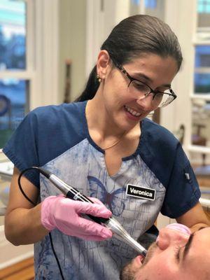 Veronica taking photos of the patient's teeth using an intra-oral camera. Pictures are taken of all our patients at their first visit