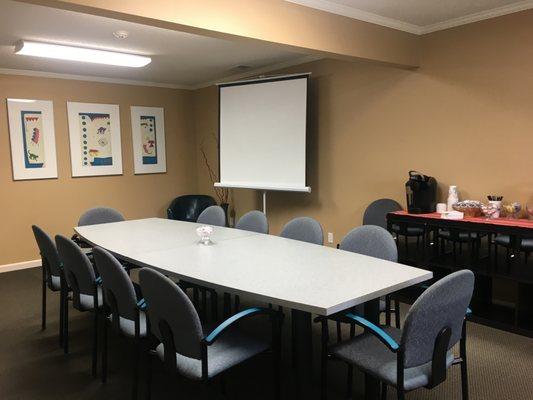 Executive Conference room setup with projector screen and complementary coffee.