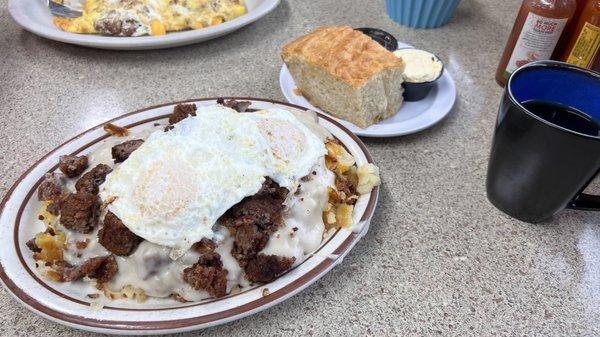 Jumbo's special with hash browns with chicken fried steak bites covered in sausage gravy with two eggs on top!