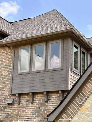 A spacious, modern kitchen features white cabinets, white countertops, and a large central island with a stovetop...