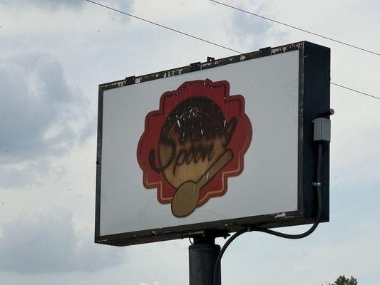 barely legible business' sign, located alongside the street