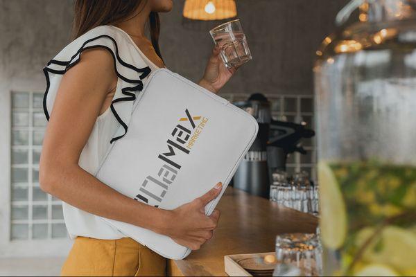 A staff member holds a branded 2DaMax Marketing laptop bag.
