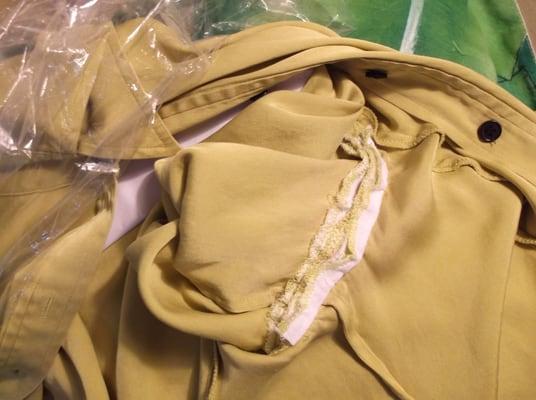 Detail, inside arm opening. A coarse piece of white fabric was sewn to the fabric in a very poor attempt to fix it.
