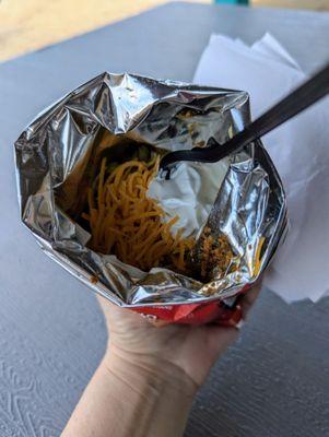 Walking taco with extra cheese and sour cream