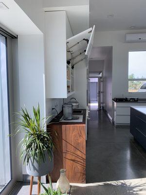 Bi-fold lift up doors for uppers. Select Walnut countertop with waterfall edge and oil finish.