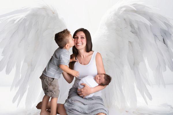 "A mother's love captured in timeless beauty -- angel wings, sweet kisses, and the joy of welcoming new life."