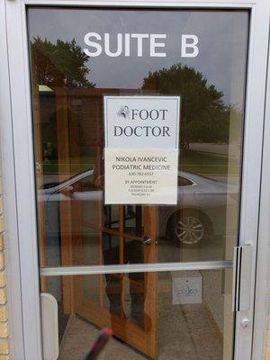 Front door entrance with hours.