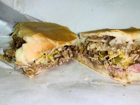 Cuban sandwich traditional style Sliced roast pork sliced ham Swiss cheese pickles mustard on Cuban bread flattened in the press grill