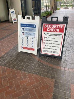 Here's said sign- "laptops outside of the bag & no more than x2 guests per screening entry" where?