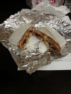 Raisin bagel with cream cheese and grape jelly