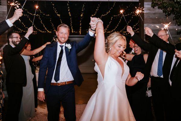 " Pure joy as the newlyweds make their grand exit under a sparkling canopy of love and celebration ."