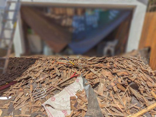 After wood slate removed from existing garage before it was carted away. Pitchfork and rakes were used to remove shingles from the roof.