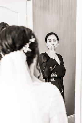 The bride's best friend, blowing a kiss of love and support before the ceremony begins.