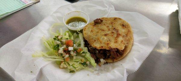 Gordita with pico de gallo and green hot sauce
