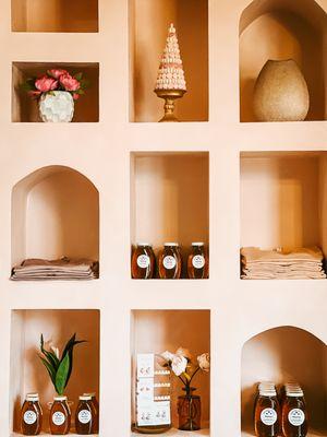 A display case showcasing locally made honey that is available for purchase in store.