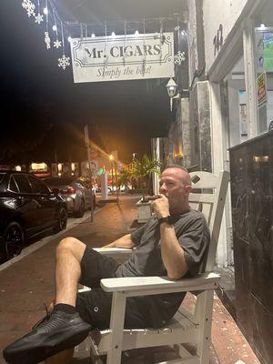 Seating outside under the sign to enjoy your cigar