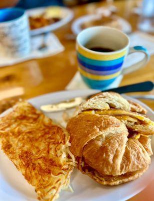 11/2025 - Hybrid egg sandwich. Fried egg, Taylor ham pork roll and cheddar on a croissant with hash browns, and great black coffee!