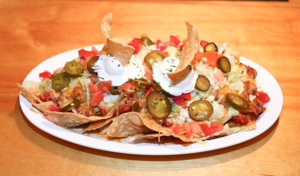 ULTIMATE NACHOS Shredded lettuce, diced tomatoes, sour cream & jalapeños & topped off with our chili cheese nachos