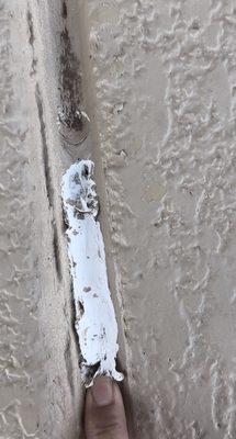 Another photo of the wet paint and caulking it between the seams of our driveway a month after it was done