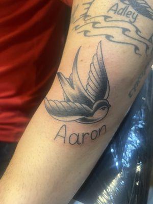 The lower tattoo that says "Aaron" was done by Laura.