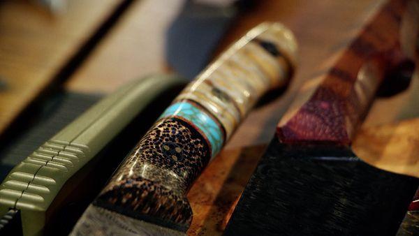 The handle of a chef knife with segmented scales of Brain Corral, Turquoise with brass webbing, and a Wooly Mammoth Molar tooth.