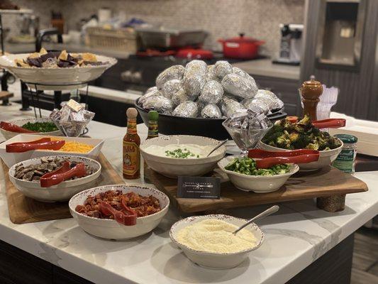 Baked Potato Bar, with a variety of different toppings, sauces, and meats.