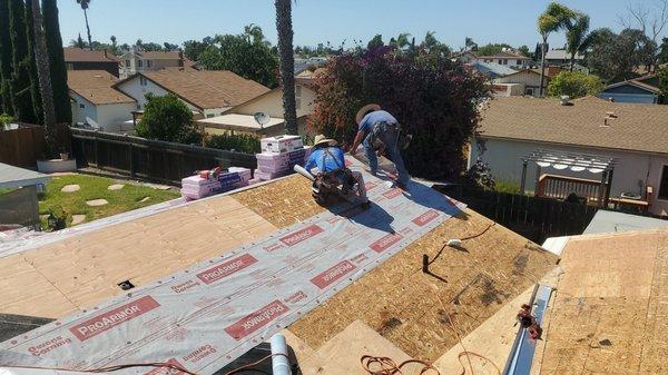 applying underlayment over the wood for this new roof installation in Mira Mesa