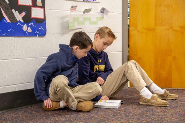 Sixth grader reading to little buddy