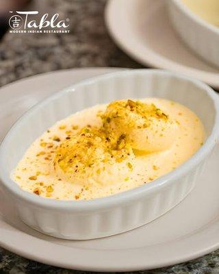 Treat yourself to the delightful taste of Rasmalai -- soft, spongy paneer soaked in sweet, saffron milk.