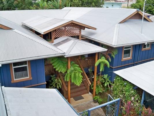 Aerial view. Sitting back off the street enclosed in a wall and gate.
