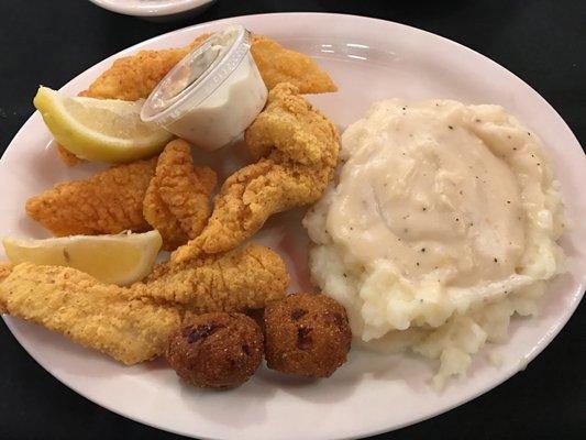 Catfish plate with mashed potatoes, hush puppies, coleslaw, and rolls.