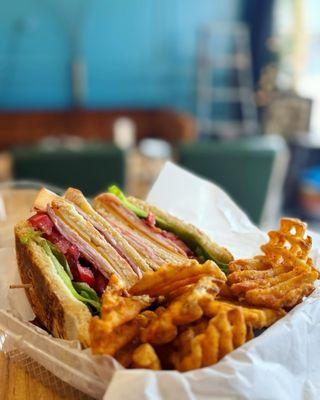 Club sandwich with seasoned waffle fries