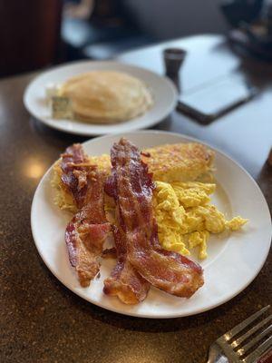 Hash browns, bacon, eggs and pancakes