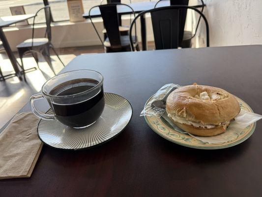 Black drip coffee and bagel with cream cheese