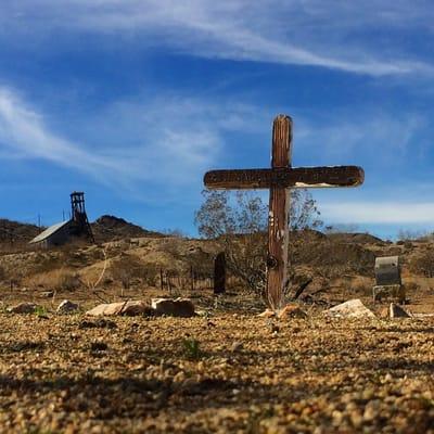 One of the old wooden crosses with a name that can barely be seen.
