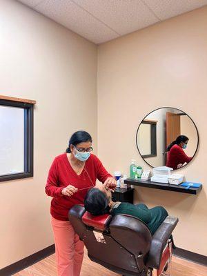 Our Eyebrow Threading Specialist, Pabitra threading her client eyebrows & upper lip.