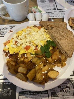 Scrambled Eggs, Hash, Feta Cheese, Tomatoes, and Wheat Toast.