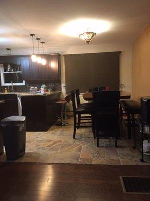 Dining room with stone flooring installed and new wood floor in living room.