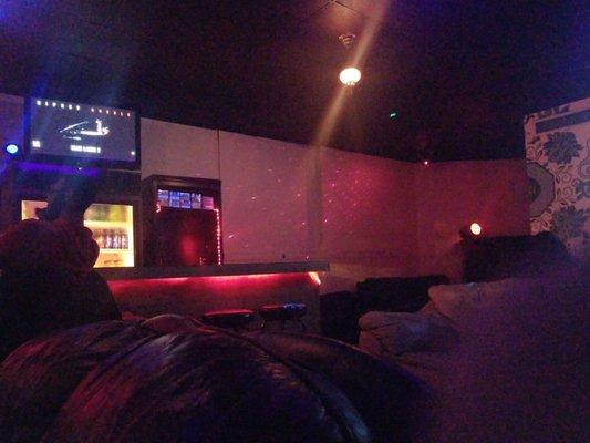 Screen where various music videos play, more seating with restroom back further.
