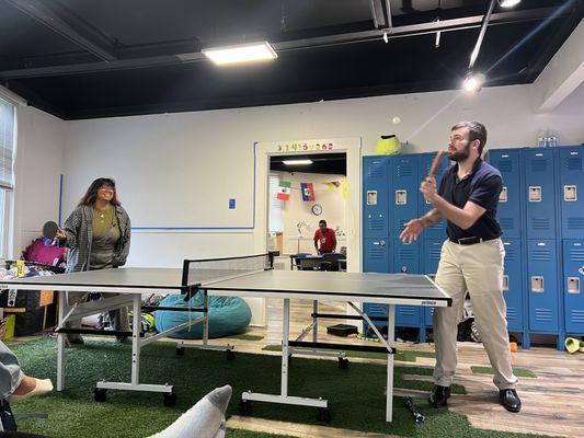 Teachers are playing ping pong at Washington Square Academy.