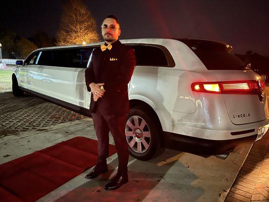 A luxurious white stretch limousine decorated for a wedding.