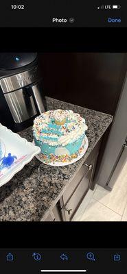 This was the cake received. it looks like the teal frosting all melted down all over the cake. Super messy border on top.