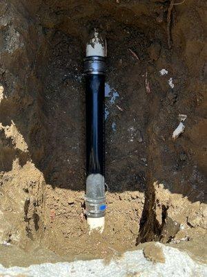 Repairing a broken section of PVC sewer line with new ABS plastic pipe and code approved heavy duty couplings.