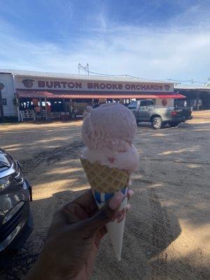 2 scoops of strawberry ice cream on a waffle cone