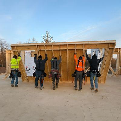In the framing stage of a custom home build.  Wall Raising with Alignment & Securing to define the layout & shape of home.